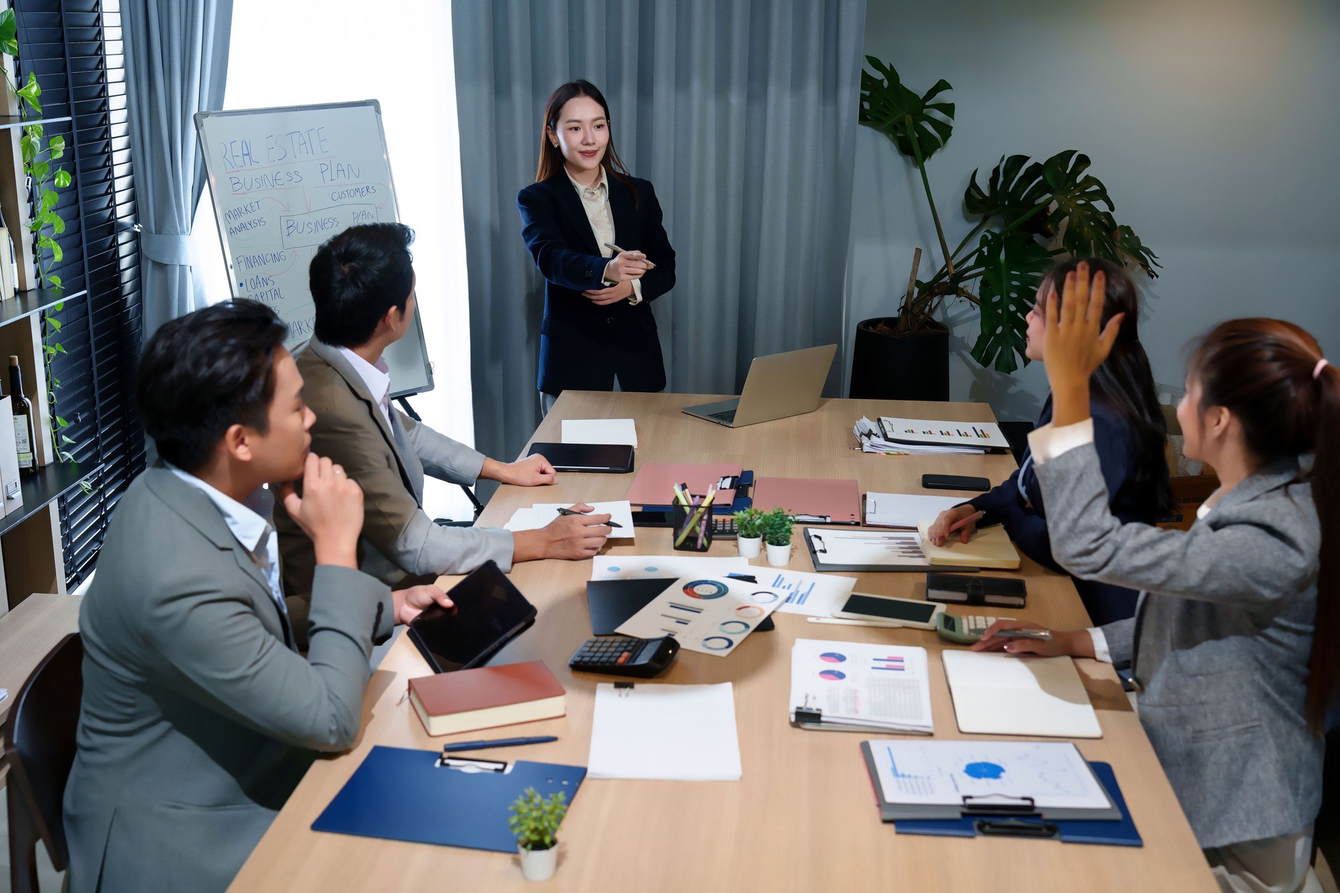 Asian Business Team Meeting Real Estate Business Plan Strategy in Office Collaboration Brainstorming Ideas with Adult Professionals