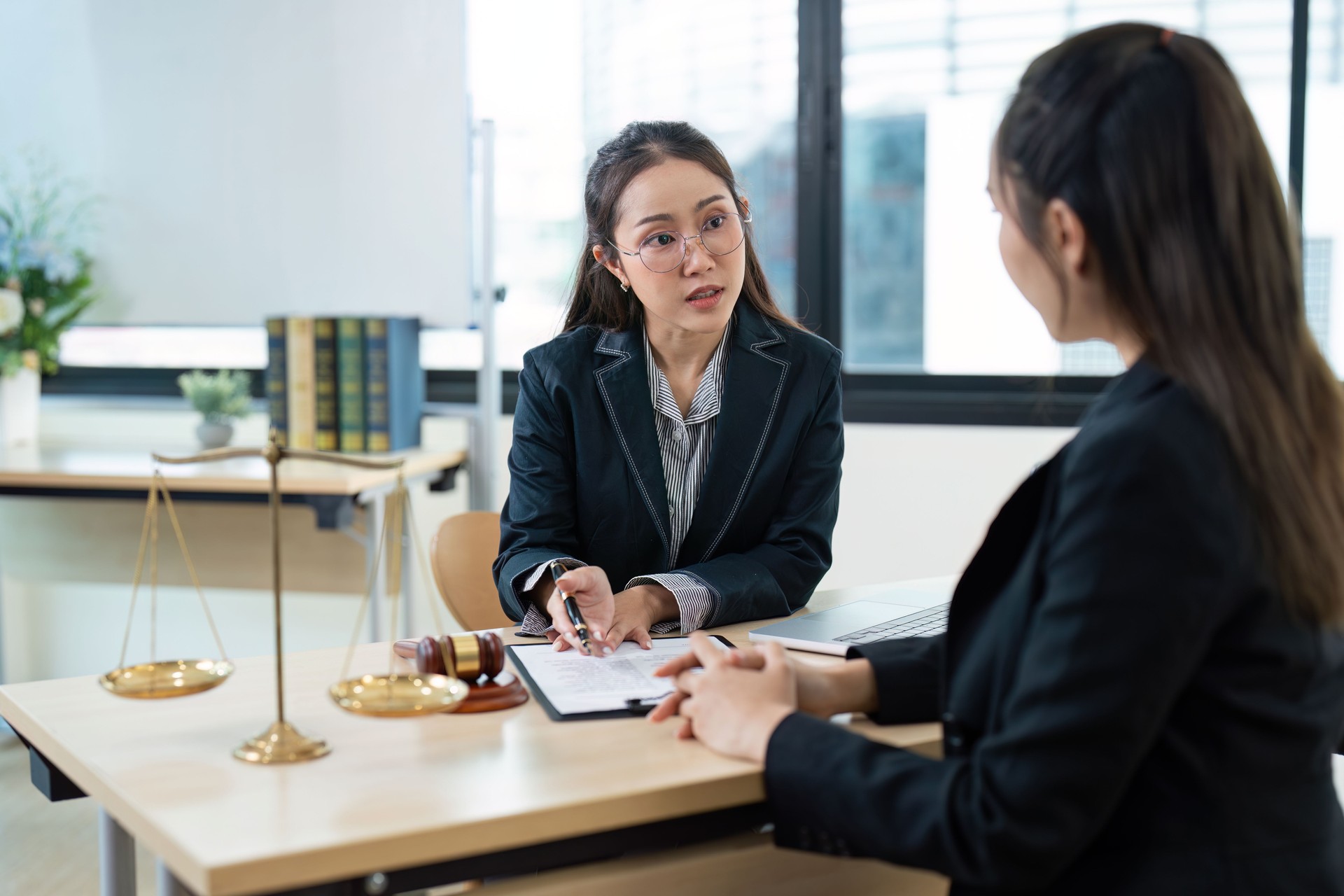 Professional Female Lawyer Consultation Client in Modern Office with Legal Documents and Scales of Justice